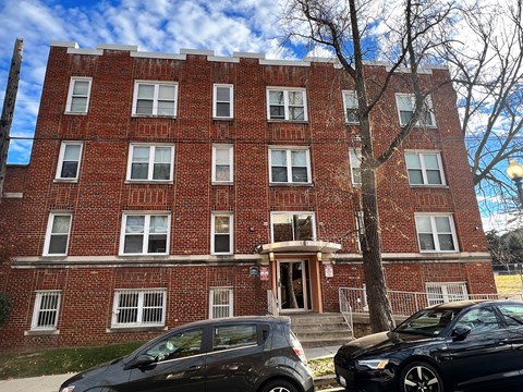 a red brick building with cars parked in front of it